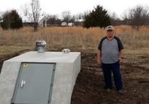 Man standing next to a storm shelter | Okay, OK