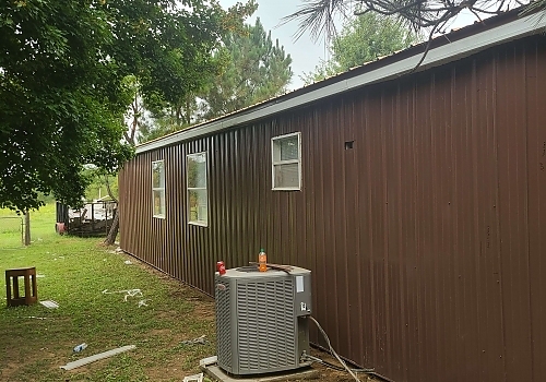 Rear view of brown house and installation process in Texanna, OK